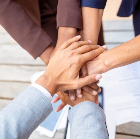 Successful business team expressing unity and putting their hands together. Closeup of people stacking hands. Team success or support concept